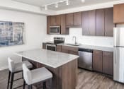 Thumbnail 14 of 40 - a kitchen with a marble counter top and stainless steel appliances at Maven on Broadway, Rochester