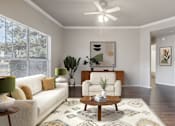Thumbnail 1 of 17 - A living room with a white couch, a coffee table, and a rug.