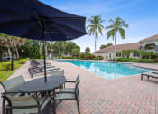 Thumbnail 11 of 21 - a swimming pool with tables and chairs and umbrellas at Gateway Club, Boynton Beach, 33436