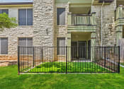 Thumbnail 10 of 23 - an apartment building with a yard behind a iron fence