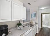 Thumbnail 9 of 26 - a kitchen with white cabinets and a sink and a dishwasher at Highlands at Faxon Woods, Massachusetts