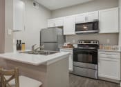 Thumbnail 1 of 23 - a kitchen with stainless steel appliances and white cabinets