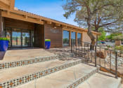 Thumbnail 20 of 33 - a building with stairs and a glass door with a tree in front of it at Acacia Gardens, Albuquerque, NM, 87111