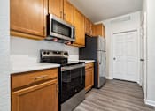 Thumbnail 5 of 23 - An open-concept apartment with updated lighting, stainless steel appliances, quartz countertops, vinyl plank wood style flooring and wooden cabinets.