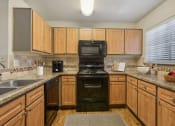 Thumbnail 6 of 23 - a kitchen with black appliances and wooden cabinets