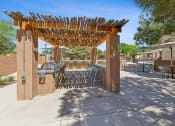 Thumbnail 33 of 33 - a patio with tables and chairs and a pergola at Acacia Gardens, Albuquerque, NM, 87111