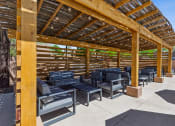 Thumbnail 27 of 33 - a covered patio with chairs and tables under a wooden structure  at Acacia Gardens, Albuquerque, NM