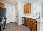 Thumbnail 4 of 23 - An open-concept apartment with updated lighting, stainless steel appliances, quartz countertops, vinyl plank wood style flooring and wooden cabinets.