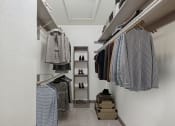 Thumbnail 4 of 23 - a spacious closet with clothes hanging on a rack and a shelf