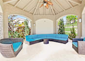 Thumbnail 17 of 27 - a covered patio with a blue couch and chairs at Altezza High Desert, Albuquerque, 87111