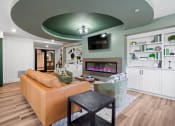 Thumbnail 18 of 33 - a clubroom with a couch and a fireplace at Edgebrook Residences, Merrimack, NH