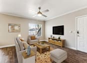 Thumbnail 7 of 27 - an open living room with a ceiling fan and a tv at Altezza High Desert, Albuquerque