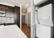 Thumbnail 6 of 22 - a kitchen with a washer and dryer and a door to a laundry room at Glenwood at Grant Park Apartments, Atlanta, GA