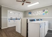 Thumbnail 14 of 23 - A room with a white ceiling fan and a wall with a poster of a washing machine.