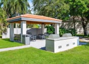 Thumbnail 16 of 21 - a gazebo with a grill and a table and chairs in a yard at Gateway Club, Boynton Beach, FL