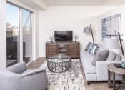 Thumbnail 5 of 40 - a living room with a couch and a chair and a tv at Maven on Broadway, Rochester, MN