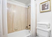 Thumbnail 12 of 37 - A bathroom with a wooden wall and a white towel rack.