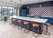 Thumbnail 31 of 40 - a communal kitchen with bar stools and a large window with a city view at Maven on Broadway, Minnesota, 55904