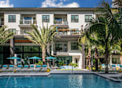 Thumbnail 22 of 35 - Pool deck with lounge chairs and umbrellas  | District at Rosemary at The District at Rosemary, Florida, 34236