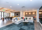 Thumbnail 11 of 40 - a resident clubhouse with couches tables and chairs at Emblem Alpharetta, Alpharetta, GA