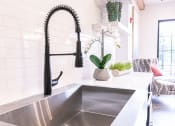 Thumbnail 9 of 40 - a kitchen sink with a black faucet at Emblem Alpharetta, Alpharetta, GA
