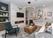 Thumbnail 5 of 40 - a living room with a fireplace and a tv on the wall at Emblem Alpharetta, Alpharetta, Georgia