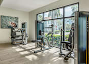 Thumbnail 17 of 41 - A gym with a treadmill, weights, and exercise equipment.