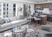 Thumbnail 3 of 40 - a living room and kitchen space with a white couch and counter stools at Maven on Broadway, Rochester, MN