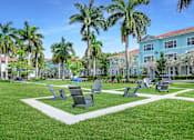 Thumbnail 23 of 41 - A park with benches and palm trees at Floresta apartments in Jupiter, FL