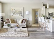 Thumbnail 3 of 39 - A modern living room with a white sofa and a large abstract painting on the wall.