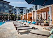 Thumbnail 15 of 39 - A row of sun loungers are arranged on a patio.