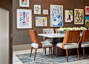 Thumbnail 35 of 39 - A dining room with a table surrounded by chairs and pictures on the wall.
