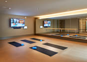 Thumbnail 27 of 39 - A yoga studio with mats and screens on the wall.