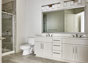 Thumbnail 11 of 39 - A white bathroom with a toilet, sink, and mirror.