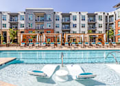 Thumbnail 13 of 39 - A swimming pool with lounge chairs and a fountain in the middle of it.