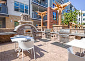 Thumbnail 21 of 39 - A patio with a table, chairs and a fireplace.