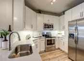 Thumbnail 6 of 39 - A modern kitchen with stainless steel appliances and white cabinets.