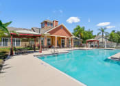 Thumbnail 5 of 12 - a pool with chairs and umbrellas in front of a building at Bella Vista on Park, Florida, 33563