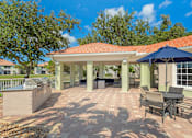 Thumbnail 12 of 29 - Outdoor community grilling area with dining tables and lounge seating