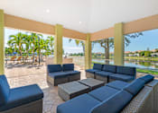 Thumbnail 13 of 29 - A patio with blue cushioned furniture and a view of the water