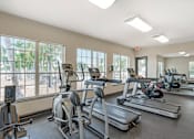 Thumbnail 18 of 29 - A gym with treadmills, elliptical machines, and other exercise equipment.