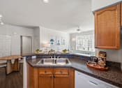 Thumbnail 7 of 26 - A kitchen with a sink, a dishwasher, and a counter.