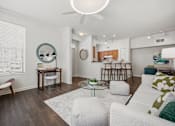 Thumbnail 4 of 26 - A living room with a white couch and a coffee table.