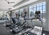 Thumbnail 20 of 38 - A gym with treadmills and elliptical machines.