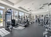 Thumbnail 19 of 38 - A spacious gym with various exercise equipment and a tiled floor.