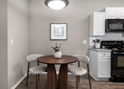 Thumbnail 8 of 38 - A kitchen with a table and chairs.