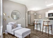 Thumbnail 3 of 38 - A modern living room with a white chair and ottoman.