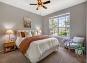 Thumbnail 4 of 38 - A bedroom with a large bed and a ceiling fan.