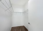 Thumbnail 12 of 38 - A white room with a brown carpet and a door on the right.