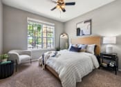 Thumbnail 1 of 38 - A bedroom with a large bed and a window with a view of the street outside.
